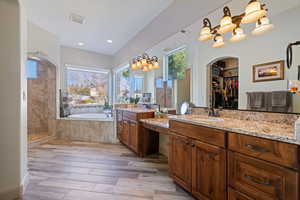 Bathroom with vanity, hardwood / wood-style floors, and plus walk in shower