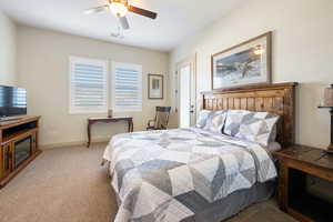 Bedroom with ceiling fan and light carpet