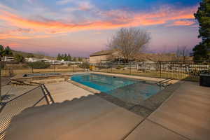 Pool at dusk featuring a patio area