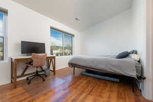 Bedroom with hardwood / wood-style flooring and vaulted ceiling