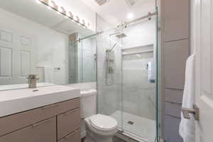 Bathroom with vanity, toilet, and walk in shower