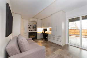 Home office with built in desk and light wood-type flooring