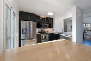 Kitchen featuring stainless steel appliances, kitchen peninsula, and sink