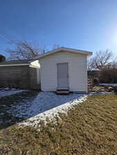 Snow covered structure with a yard