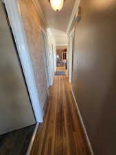 Corridor with crown molding and dark hardwood / wood-style flooring