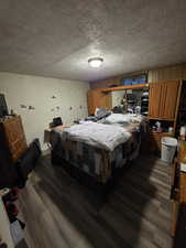 Bedroom featuring dark wood-type flooring and a textured ceiling