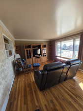 Living room featuring wood-type flooring and crown molding