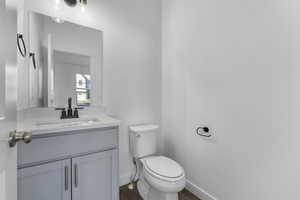 Bathroom with vanity, hardwood / wood-style flooring, and toilet