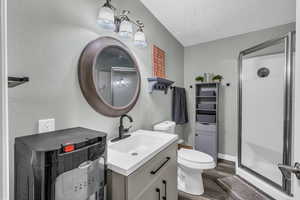 Bathroom featuring hardwood / wood-style flooring, vanity, toilet, and walk in shower