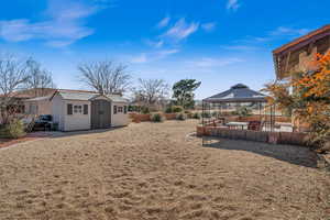 View of yard with a shed, a gazebo, and a jacuzzi