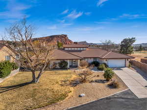 Ranch-style house featuring a garage, a mountain view, and a front yard