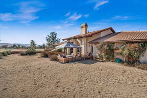 Rear view of property featuring a gazebo and a patio