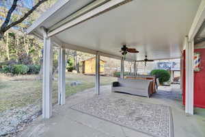 View of patio with ceiling fan and a storage unit