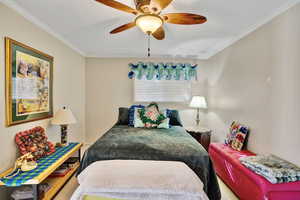 Bedroom featuring crown molding, ceiling fan, and a textured ceiling