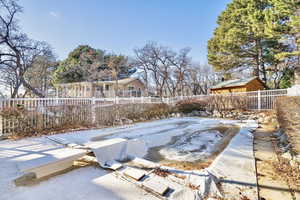 Yard layered in snow with a covered pool and a patio area