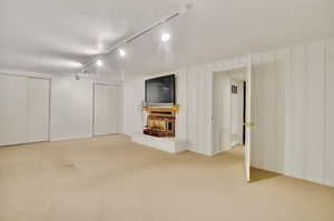 Unfurnished living room with light colored carpet and a textured ceiling