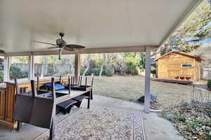 View of patio featuring ceiling fan and a shed