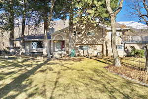 View of front of house with a mountain view and a front lawn