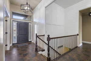 Entryway featuring an inviting chandelier and wood walls