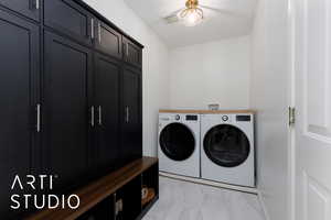 Clothes washing area featuring cabinets and independent washer and dryer