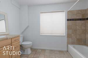 Full bathroom with tile patterned flooring, tiled shower / bath, vanity, and toilet