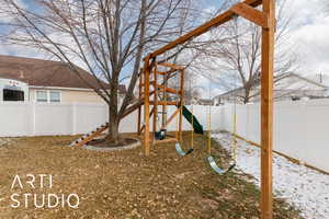 Snowy yard featuring a playground