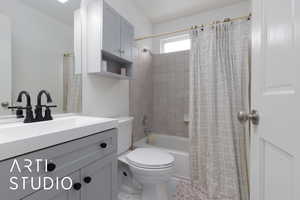 Full bathroom featuring vanity, shower / tub combo, and toilet