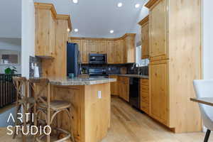 Kitchen featuring a breakfast bar area, refrigerator, electric range, dishwasher, and decorative backsplash