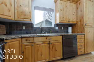 Kitchen with sink, dishwasher, backsplash, light brown cabinetry, and light wood-type flooring