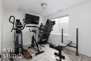 Workout room featuring light parquet flooring