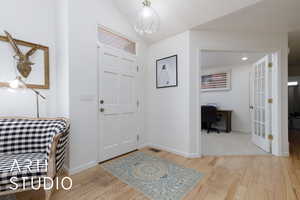 Entryway with lofted ceiling and light hardwood / wood-style flooring