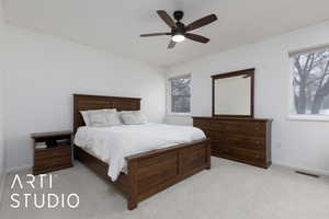 Bedroom featuring ceiling fan, light carpet, and multiple windows