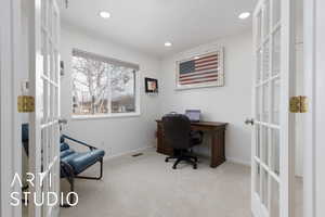 Office with french doors, light colored carpet, and crown molding