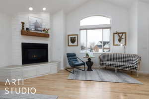 Sitting room with a fireplace, plenty of natural light, and wood-type flooring