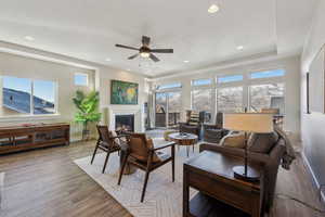 Living room with ceiling fan, a mountain view, and light hardwood / wood-style floors