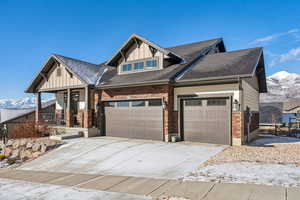 Craftsman-style house with a porch, a garage, and a mountain view