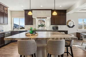 Kitchen with a mountain view, decorative light fixtures, stainless steel appliances, and sink