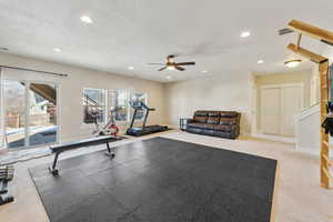 Workout area featuring ceiling fan, carpet floors, and a textured ceiling