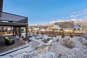 Snowy yard with a mountain view and a patio area