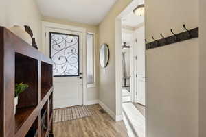 Foyer entrance with ceiling fan and light wood-type flooring