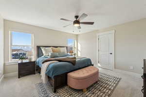 Carpeted bedroom featuring ceiling fan