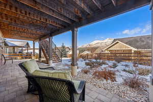 Snow covered patio with a mountain view