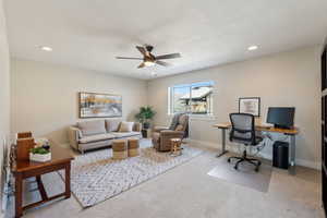 Office area featuring ceiling fan, carpet, and a textured ceiling