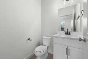 Bathroom featuring hardwood / wood-style flooring, vanity, and toilet