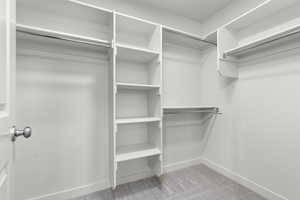 Spacious closet with light carpet