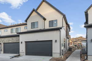 View of front of property with a garage and central air condition unit