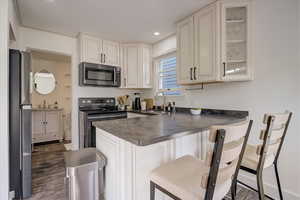 Kitchen featuring sink, a breakfast bar area, stainless steel appliances, and kitchen peninsula