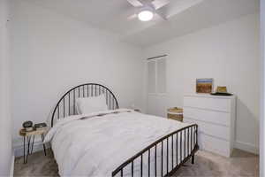 Carpeted bedroom featuring a closet and ceiling fan