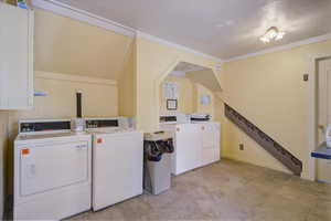 Washroom featuring crown molding and washing machine and dryer