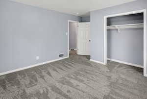 Unfurnished bedroom featuring a closet and carpet flooring